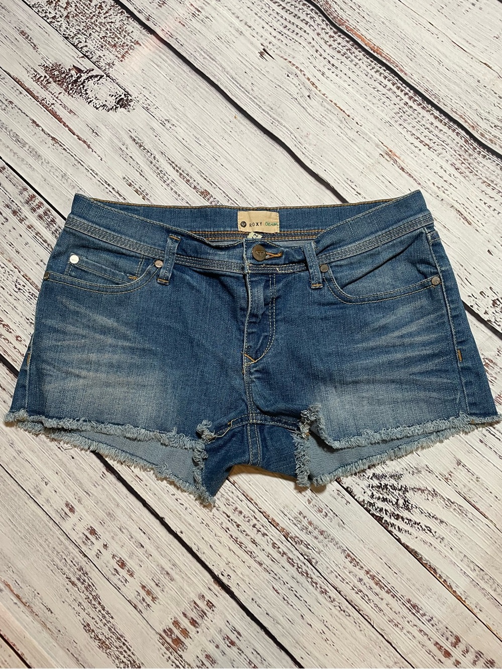 Roxy blue denim cut-off shorts, medium wash and a raw frayed hem. Size 5/27.